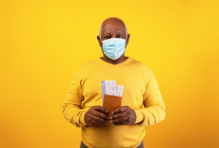 Senior Man Prepared for International Travel With Passport and Tickets During Health Precautionsの写真素材