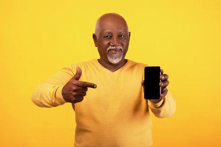 Joyful Senior Man Showcasing Smartphone With Blank Screen for App Advertisementの写真素材