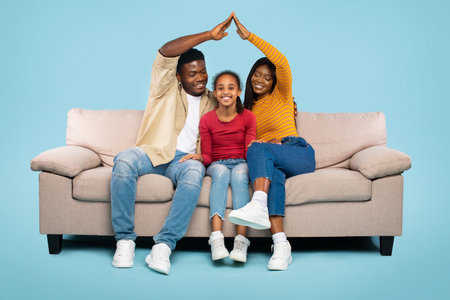 Family Enjoying Playful Time Together on a Cozy Sofa in a Bright Roomの写真素材