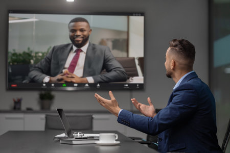 A Young Middle Eastern Businessman Holds a Video Conference With an African American CEOの写真素材