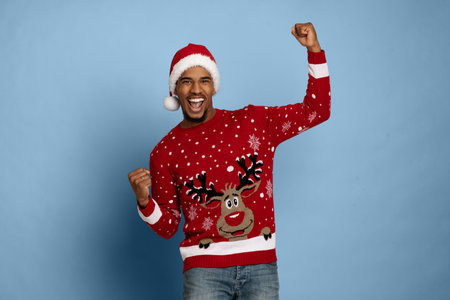 Man Celebrates Wearing a Festive Sweater and Santa Hat During the Holiday Seasonの写真素材