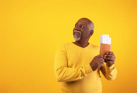 Happy Senior Black Man Excited for Vacation Holding Passport and Boarding Passの写真素材