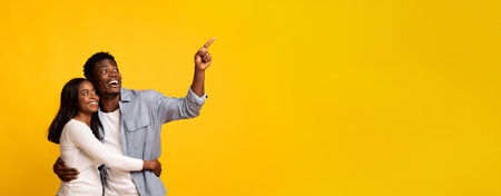 Happy Couple Enjoying Time Together While Looking up in a Bright Yellow Settingの写真素材