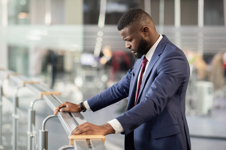 Upset african american entrepreneur standing by railingの写真素材