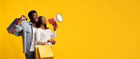 Joyful Couple Celebrating With Shopping Bags and a Megaphone Against a Bright Yellow Background