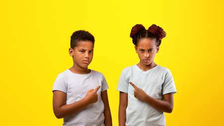 Children Showing Strong Expressions With Yellow Background During Playful Momentの写真素材