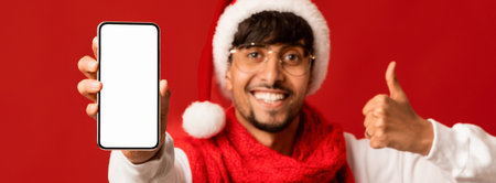 Happy Man in Festive Attire Showing Smartphone Against Red Backgroundの写真素材