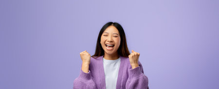 Joyful Young Woman Expressing Excitement Against a Lilac Backgroundの写真素材