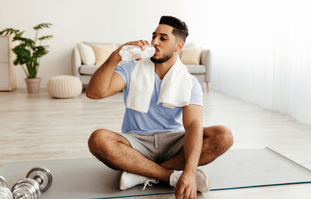 Young Man Enjoying a Break After Workout in a Bright and Modern Indoor Spaceの写真素材