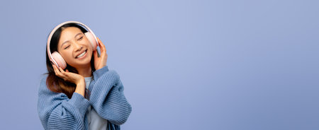 Young Woman Enjoys Music With Headphones Against a Light Blue Background