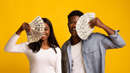 Celebrating Financial Success With Cash in Hand and Bright Smiles Against a Vibrant Backgroundの写真素材