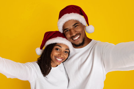 Happy Couple Celebrating Christmas With Festive Hats Against a Bright Yellow Background