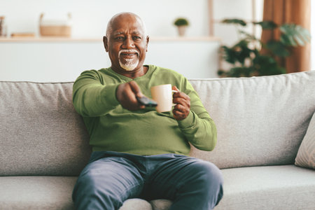 Senior Man Enjoying a Relaxing Afternoon at Home With Coffee and Television