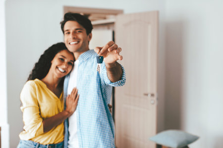 Couple Celebrating New Home With Keys in Hand in a Cozy Interior Settingの写真素材