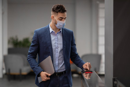 Middle Eastern Man in Formal Wear Using Access Card at Office Security Entranceの写真素材