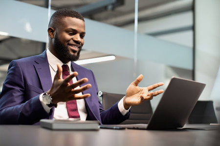 Charismatic black CEO having business conference, using laptop