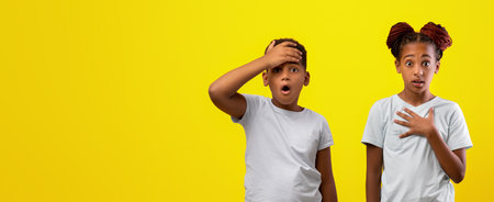 Children Expressing Surprise With Shocked Expressions Against a Bright Yellow Backgroundの写真素材