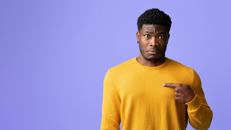 Guy in Yellow Sweater Showing Surprise With Purple Backgroundの写真素材