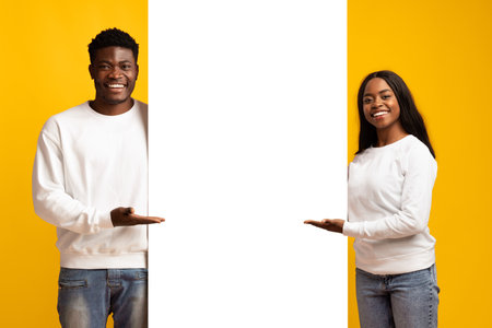 Smiling Couple Holding a Blank Sign Against a Bright Yellow Background