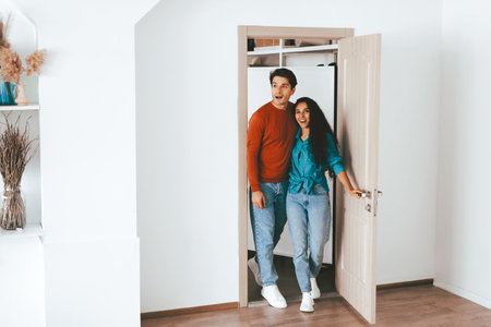 Couple Happily Entering Their New Home Together in a Bright and Modern Settingの写真素材