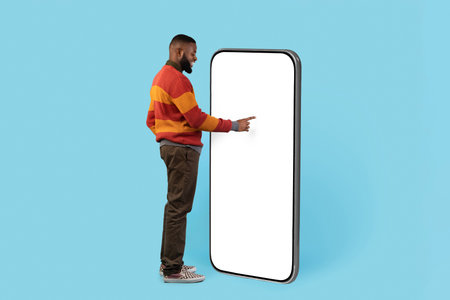 Interested Black Man Standing Near Big Blank Smartphone And Touching White Screen