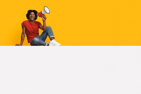 Person Sitting on Floor With Megaphone Against Bright Yellow Backgroundの写真素材