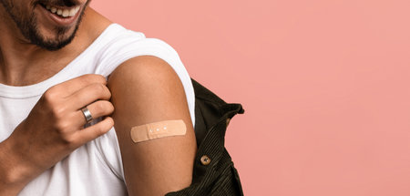 Man Showing off a Bandage on His Arm After Getting a Vaccination in a Studio Setting