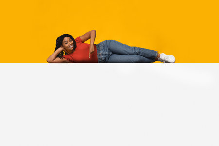 Woman in Casual Attire Poses Playfully Against a Bright Yellow Backgroundの写真素材