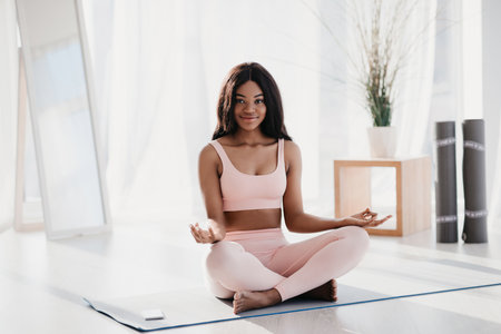 Meditation Practice of Millennial Black Woman in Sports Outfit at Homeの写真素材
