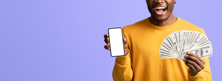 Happy Person Celebrating Success With Cash and Smartphone in Hand Against a Purple Backgroundの写真素材