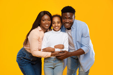 Happy Family Sharing Love and Joy in a Bright Yellow Studio Settingの写真素材
