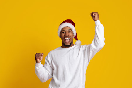 Joyful Man Celebrating With Santa Hat Against Bright Yellow Backgroundの写真素材