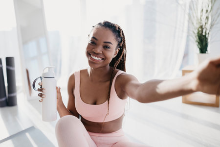 Smiling Young African American Woman Taking Selfie During Home Workout Breakの写真素材