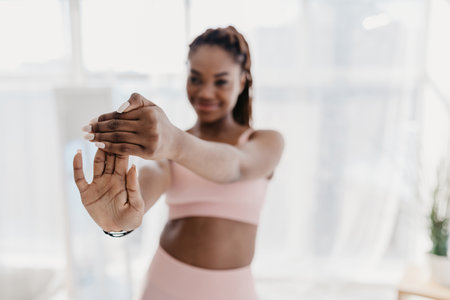 Fit Young Black Woman Stretching Indoors in a Home Gym During Covid Lockdownの写真素材