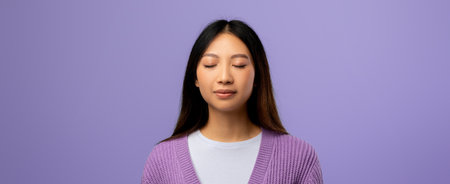 Calm Woman Practicing Mindfulness in a Studio With Purple Backgroundの写真素材