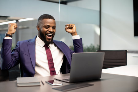 Emotional african american businessman celebrating success in businessの写真素材