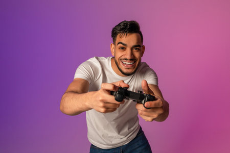 Young Arab Man Enjoys Online Gaming in Neon Lights During a Championship Competitionの写真素材