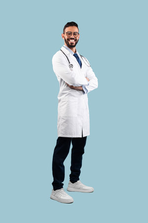 Smiling Doctor Poses Confidently Against a Light Blue Background Showcasing Professionalism and a Positive Attitudeの写真素材
