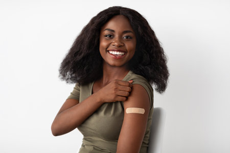 Smiling Woman Shows off Her Vaccine Bandage in a Bright and Welcoming Settingの写真素材