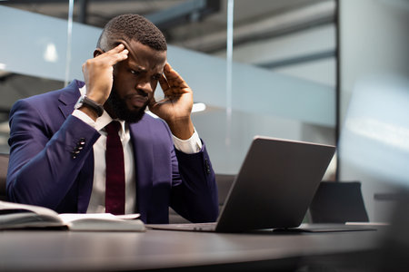 Concentrated black businessman using computerの写真素材