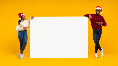 Black Couple Showcasing Christmas Advertisement in Vibrant Studio Settingの写真素材