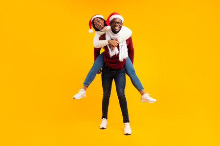 Joyful Couple Celebrating Christmas Together in Winter Outfits Against a Yellow Backdropの写真素材