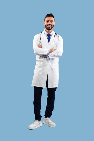 Smiling Healthcare Professional in a White Coat Against a Light Blue Background Ready for Work in a Clinical Settingの写真素材