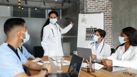 Multiracial group of doctors in face masks having medical conferenceの写真素材