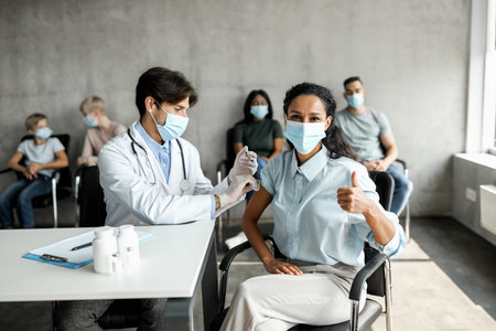 Middle-eastern lady getting vaccinated against coronavirus at clinicの写真素材