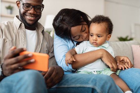 Family Joyfully Connects With Grandparents Through Smartphone While Relaxing at Homeの写真素材
