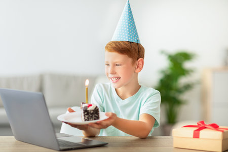 Cheerful Redhead Boy Celebrates Birthday With Online Party at Home During Isolationの写真素材