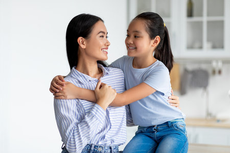 Happy Mother and Daughter Share a Joyful Moment in the Kitchen During Mothers Day Celebrationの写真素材