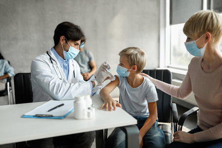 Teen boy getting vaccinated against coronavirus at clinicの写真素材