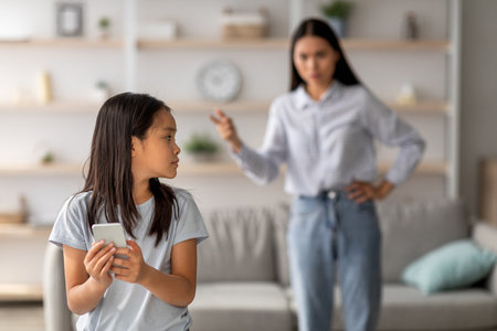 Mother Argues With Daughter About Smartphone Use During Family Timeの写真素材